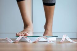 Person stepping on scale to check their weight