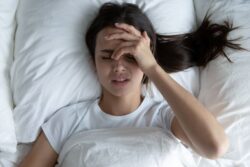 Woman lying in bed, experiencing unwanted thoughts 