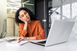Exhausted woman sleeping at her desk 